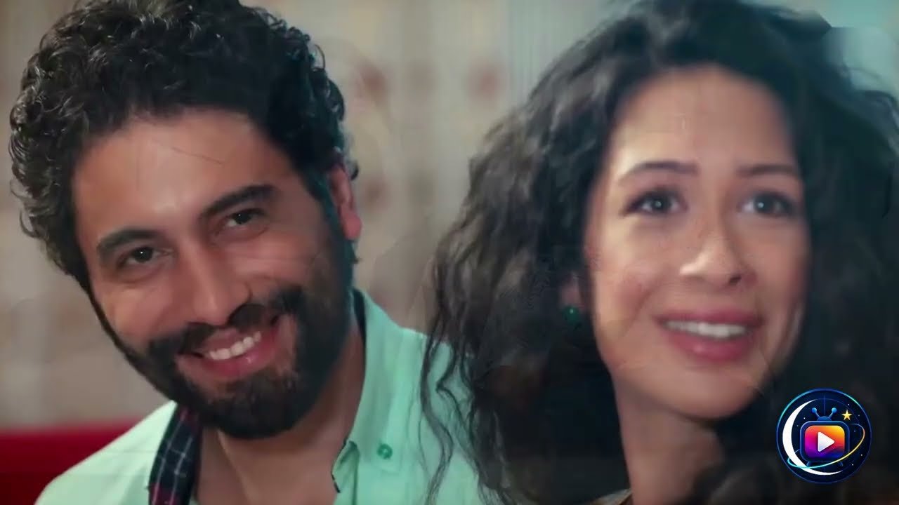 Primo piano di un uomo con la barba e i capelli scuri e ricci, camicia verde acqua, che sorride inclinando la testa accanto a una donna con lunghi capelli scuri e mossi, sorridente anche lei. In basso a destra il logo tondo di un canale.